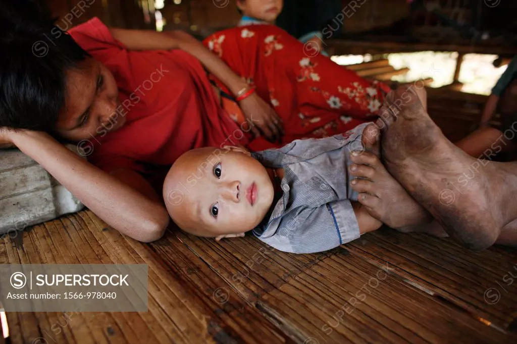 A woman lies down next to her baby in La Per Her In Myanmar Burma, thousands of people have settled near the border as a result of oppression in their...