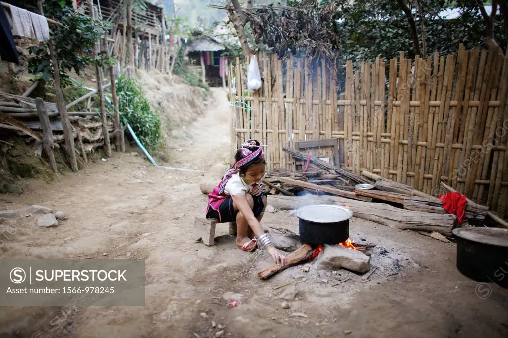 A young Longneck girl tends a cooking fire Approximately 300 Burmese refugees in Thailand are members of the indigenous group known as the Longnecks T...