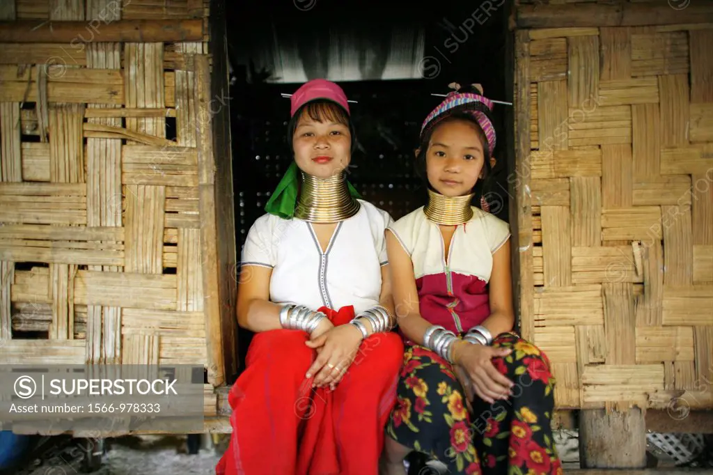 Two Longneck girls sitting outside a hut Approximately 300 Burmese refugees in Thailand are members of the indigenous group known as the Longnecks The...