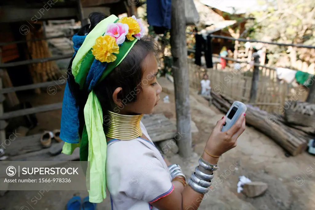 A Longneck girl examines a cell phone Approximately 300 Burmese refugees in Thailand are members of the indigenous group known as the Longnecks The la...