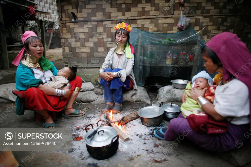 A group of Longneck women sit around a fire with their babies Approximately 300 Burmese refugees in Thailand are members of the indigenous group known...