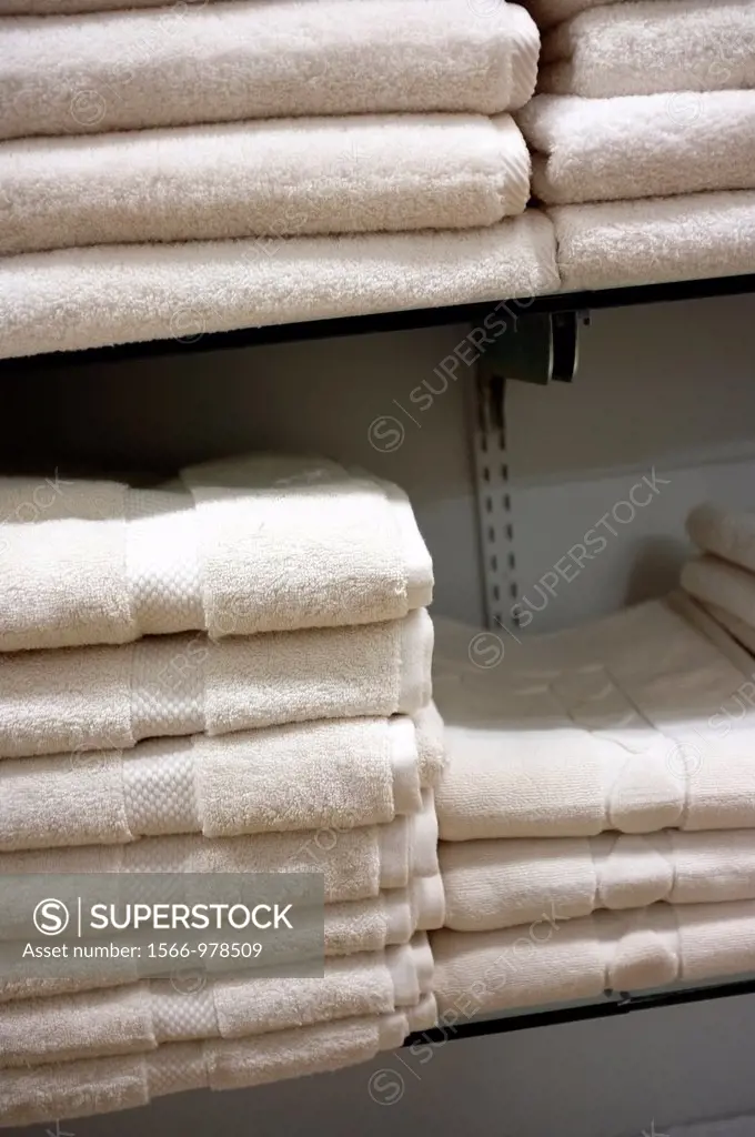White Towels Stacked on Shelves in a Retail Store Display