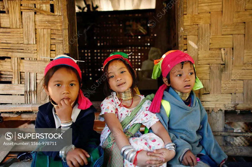 A trio of young Longneck girls outside a hut Approximately 300 Burmese refugees in Thailand are members of the indigenous group known as the Longnecks...