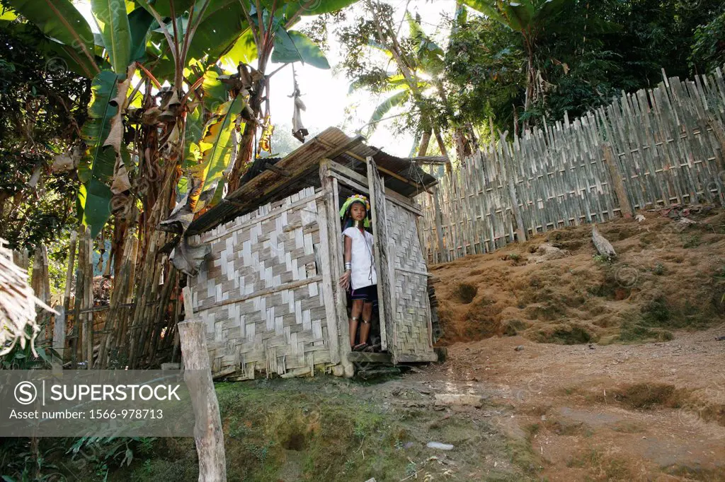 A Longneck girl stands in front of an outhouse in the village Approximately 300 Burmese refugees in Thailand are members of the indigenous group known...