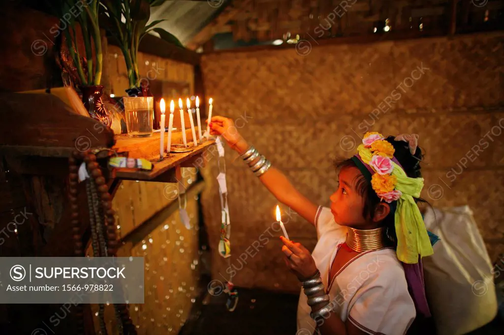 A young Longneck girl lights candles at a home altar Approximately 300 Burmese refugees in Thailand are members of the indigenous group known as the L...