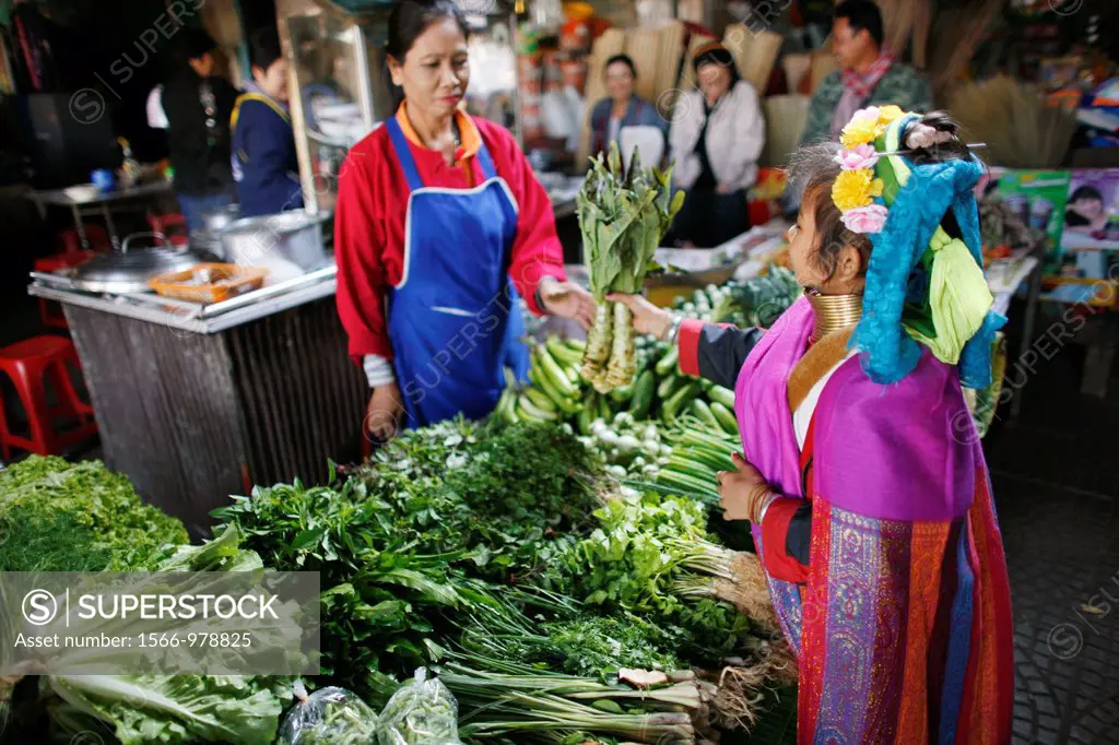 A Longneck girl selects vegetables at a local market Approximately 300 Burmese refugees in Thailand are members of the indigenous group known as the L...
