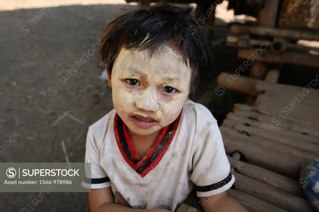 A Burmese child with decorative face painting in the camp on the border with Thailand In Myanmar Burma, thousands of people have settled near the bord...