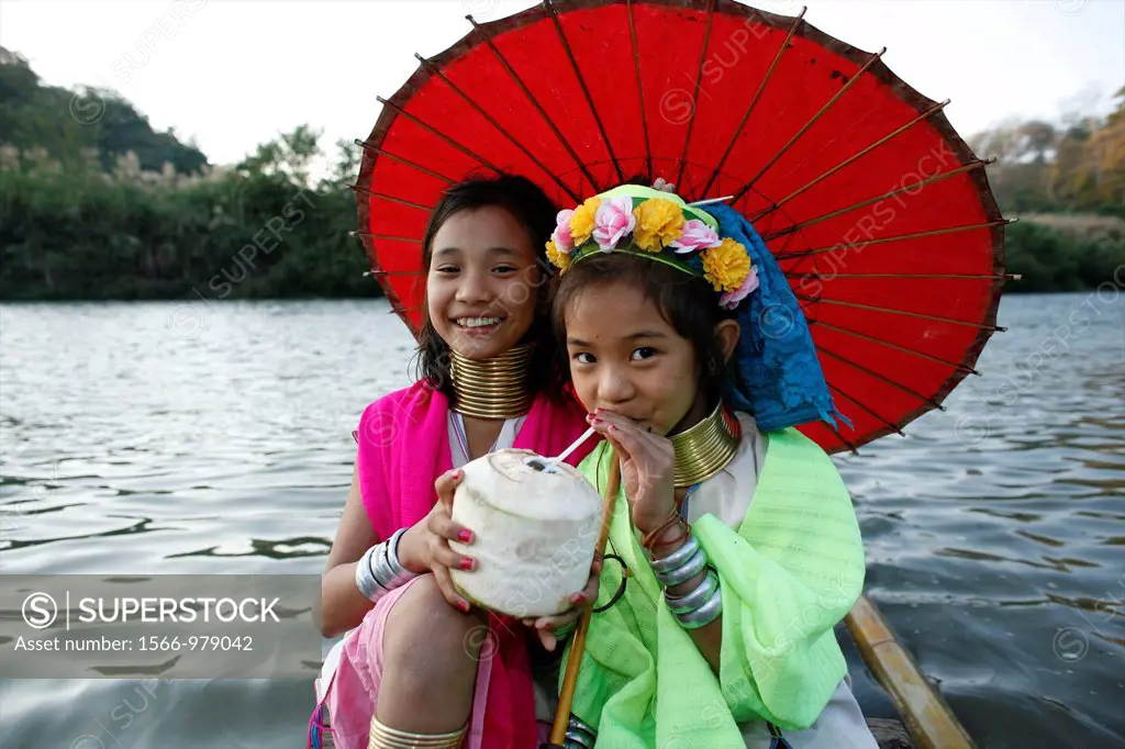 Two Longneck girls enjoy a drink on a boat Approximately 300 Burmese refugees in Thailand are members of the indigenous group known as the Longnecks T...