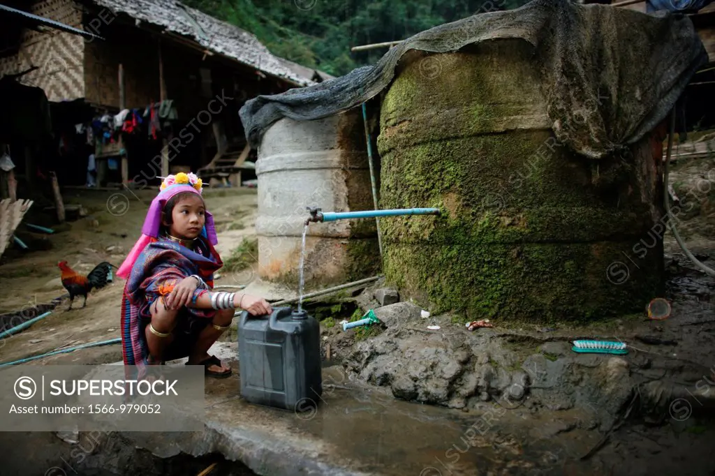 A young Longneck girl fills a jerrycan with water Approximately 300 Burmese refugees in Thailand are members of the indigenous group known as the Long...