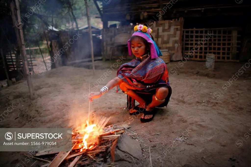A young Longneck girl watches over a fire Approximately 300 Burmese refugees in Thailand are members of the indigenous group known as the Longnecks Th...