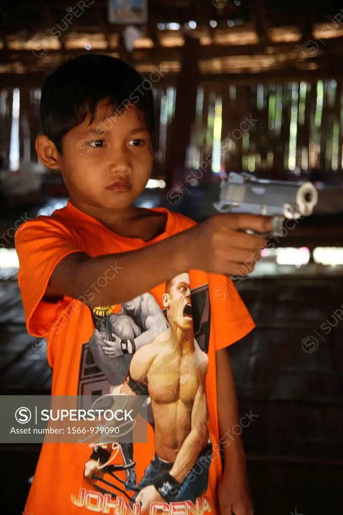 Refugee boy aims a gun in Mae Sot Around 130,000 Burmese refugees have settled in Thailand due to opression in their homeland of Myanmar Burma Approxi...