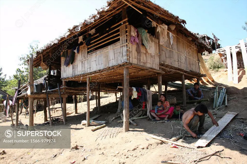 A Burmese family sitting in the shade of their hut in the displaced pesons camp near the border with Thailand In Myanmar Burma, thousands of people ha...