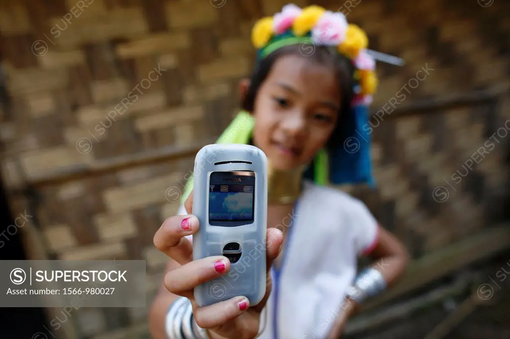 A Longneck girl takes a photo using a cell phone Approximately 300 Burmese refugees in Thailand are members of the indigenous group known as the Longn...