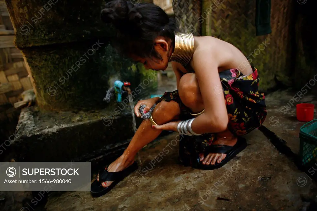 A Longneck girl adjusts her legband while showering Approximately 300 Burmese refugees in Thailand are members of the indigenous group known as the Lo...