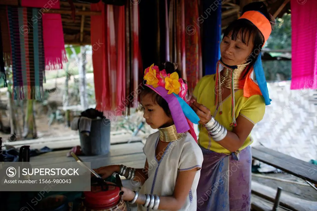 A Longneck woman helps a young girl fix her hair Approximately 300 Burmese refugees in Thailand are members of the indigenous group known as the Longn...