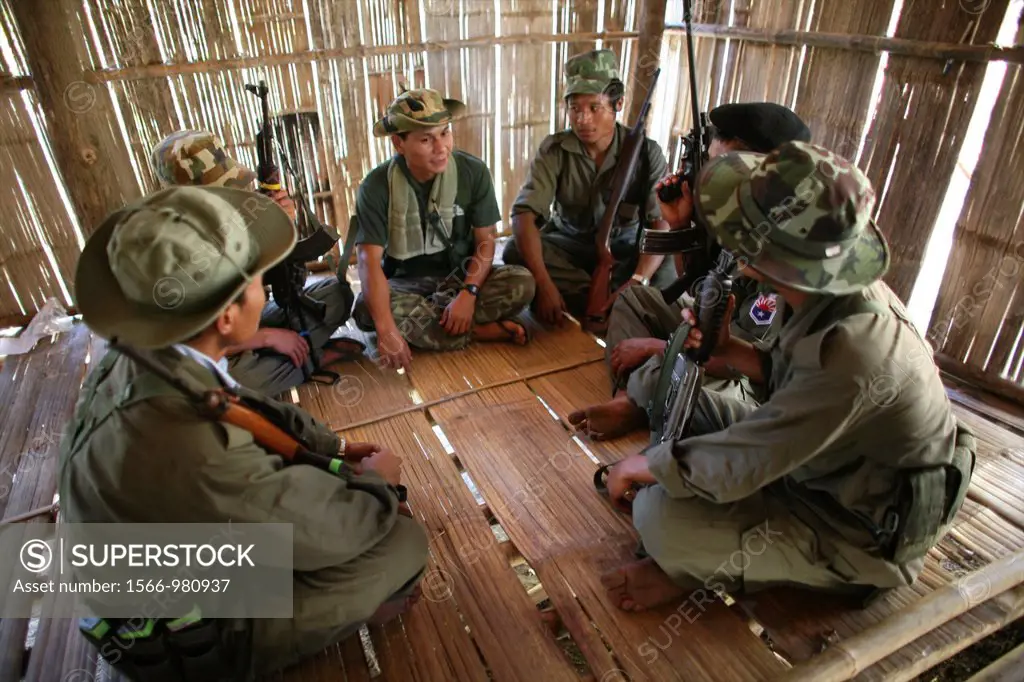 KNLA soldiers sitting in a group in a hut In Myanmar Burma, thousands of people have settled near the border as a result of oppression in their homela...