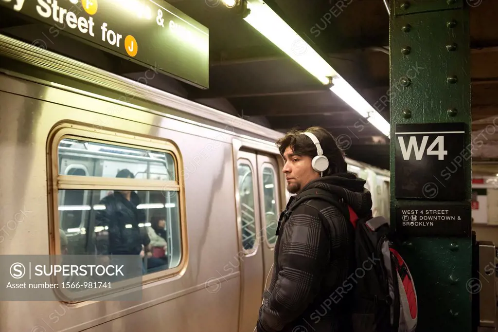 A music listener wears his over the ear headphones on a subway platform in New York