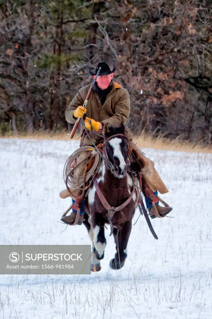 Cowboy with rifle on galloping horse