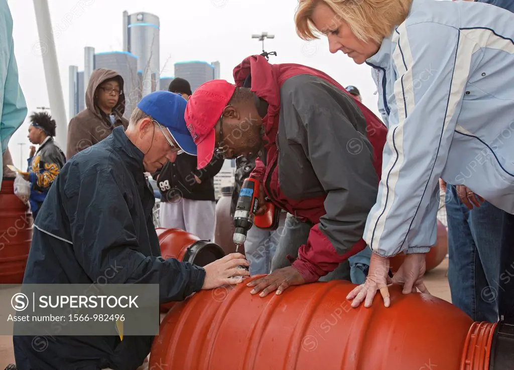 Detroit, Michigan - An instructor center helps a couple make a rain barrel during a workshop sponsored by the Sierra Club  Rain barrels collect rain w...