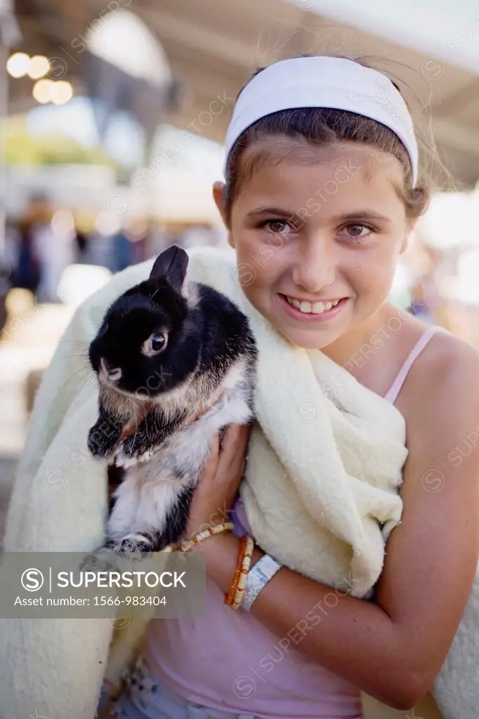 A young girl proudly holds up her rabbit at the 2007 San Mateo County Fair, San Mateo, California, USA