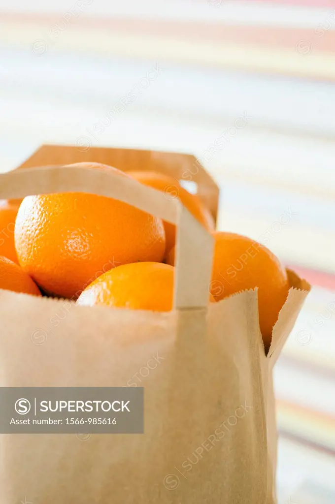 Brown paper bag full of oranges