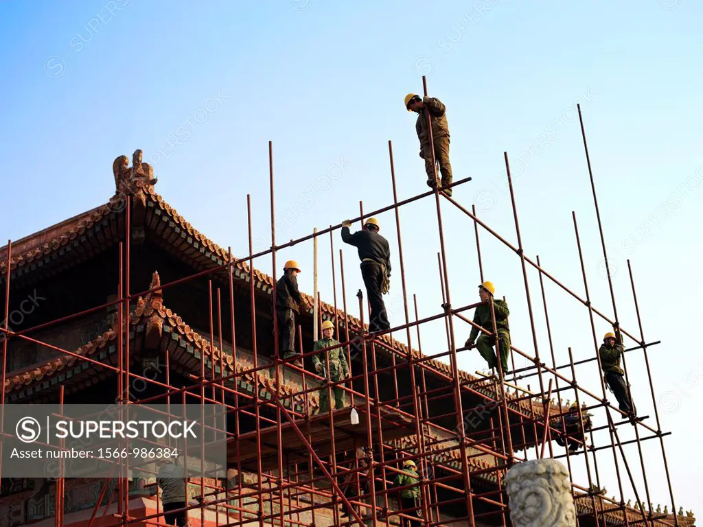 Workers climb scaffolding to reach renovations on the palace roof in the Forbidden City in Beijing, China