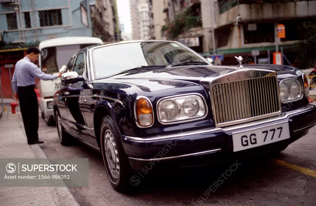 A Chauffeur polishes a Rolls Royce on a street in Central, Hong Kong  Hong Kong has more Roll Royces per capita than any other city in the world