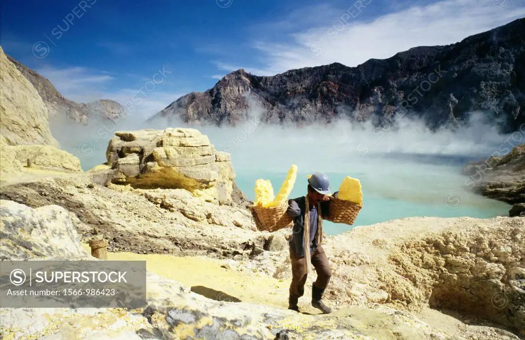 Sulphur miners pulling sulphur out of the bottom of an active volcano, carrying chunks in wicker baskets which often weigh more than the miners themse...