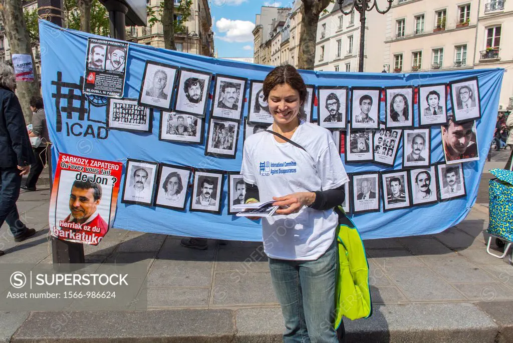 Paris, France, French Woman Distributing Leaflets in Front of Portraits of Political Missing Persons Display on Wall during May Day March in Street