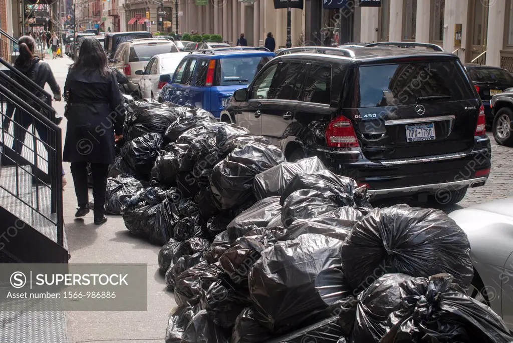 Piles of trash in plastic bags await pick-up curbside in New York
