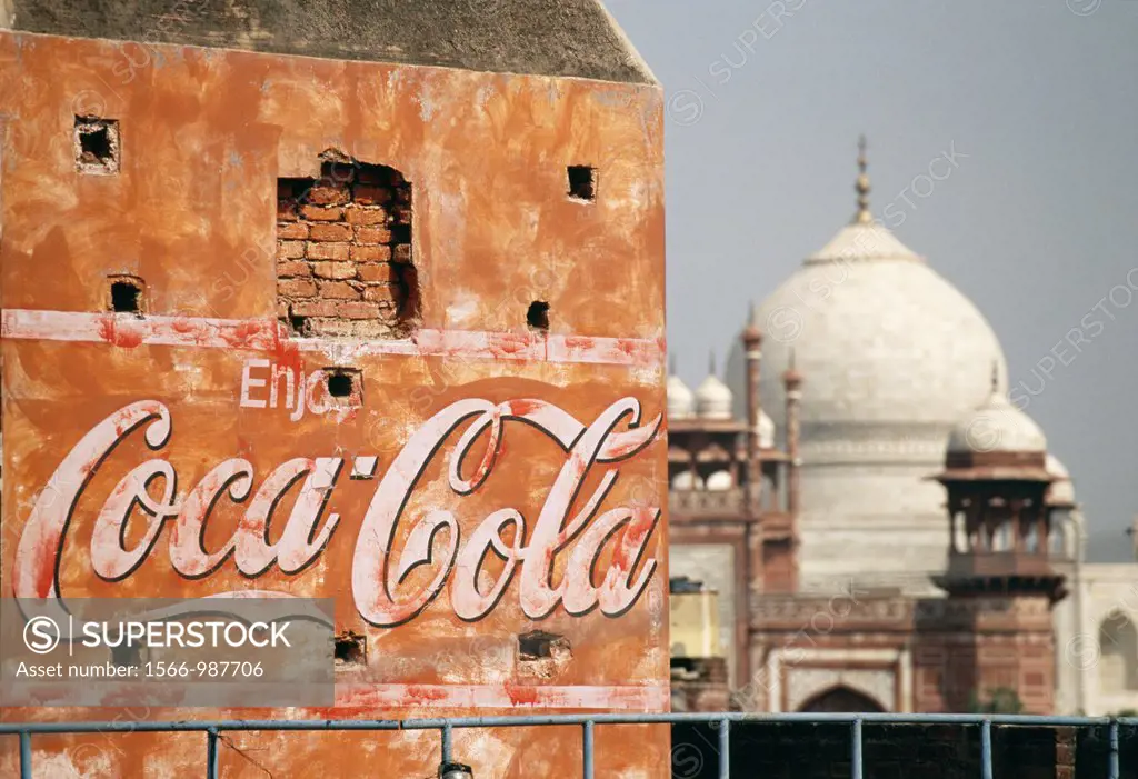 A Coca Cola billboard on an old and worn building with the Taj Mahal in the background The Taj Mahal is one of the most famous landmarks in India and ...