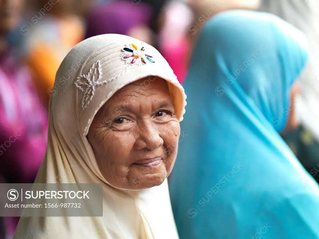 An smiling elderly Muslim woman wearing a embroidered hijab