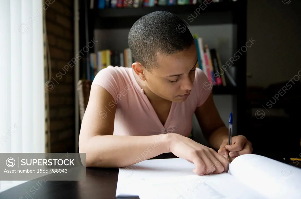 Young, African woman, making her home-work, while learning Dutch as a second language.