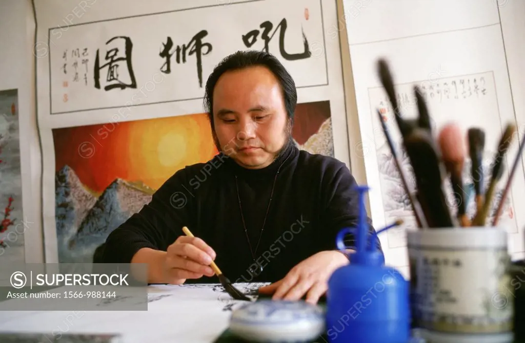 A Chinese painter paints pictures for guests traveling down the Yangtze river by boat He also does chinese Calligraphy