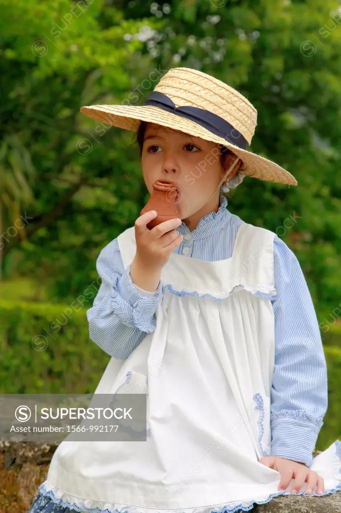 Young girl wearing traditional garments plays with a clay whistle  Sao Miguel island, Azores, Portugal
