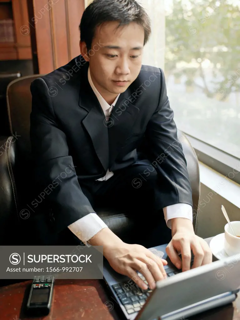 Man sits by a window utilizing his laptop for communication