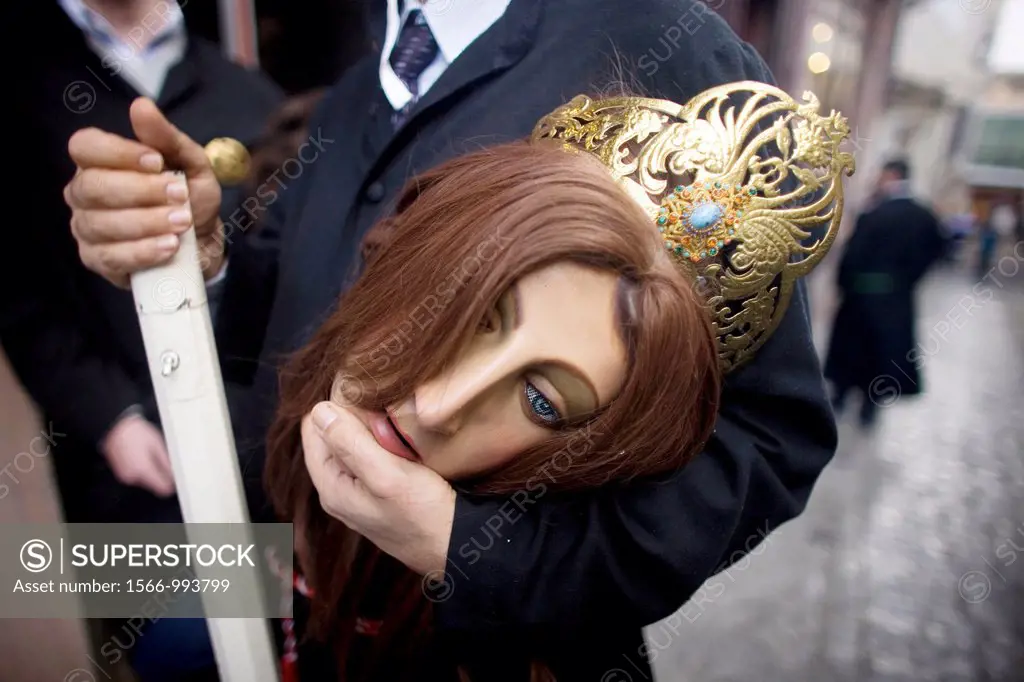 A man holds a mask and a candle during an Easter Holy Week procession in Puente Genil, in the province of Cordoba, Andalusia, Spain.