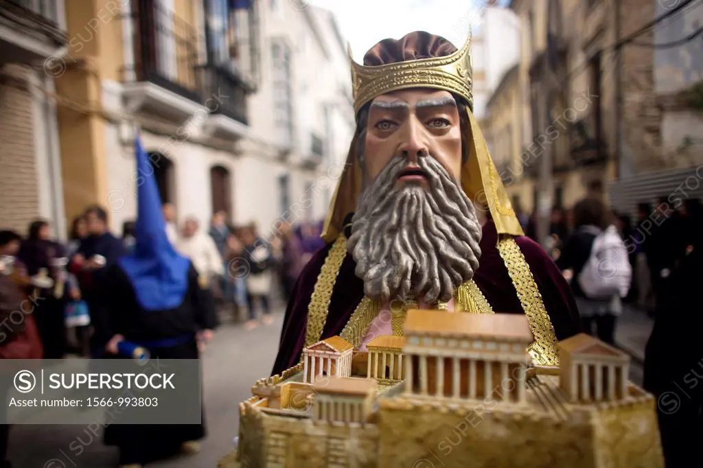 A masked man dressed as a biblical character holds a relic during an Easter Holy Week procession in Puente Genil, in the province of Cordoba, Andalusi...