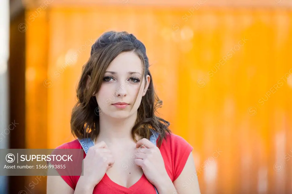 Teen girl is posing before a bright metal plate