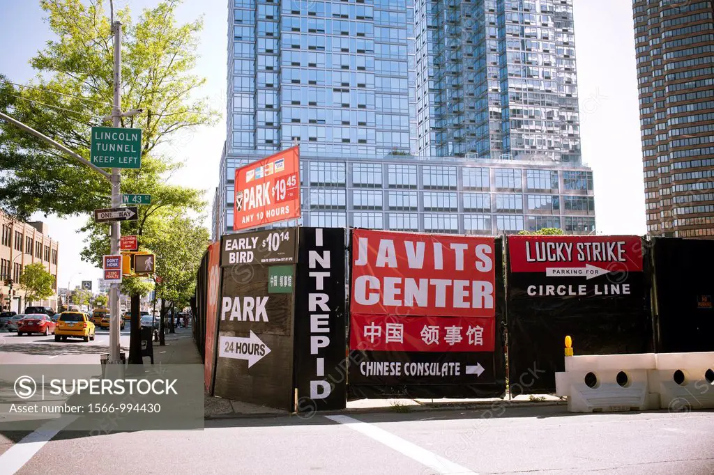 Construction shed at West 43rd Street and 11th Avenue in Midtown Manhattan in New York advertises parking for local businesses and destinations