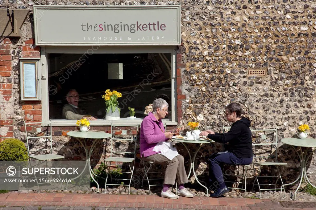 Two women enjoying tea outside The Singing Kettle Cafe, Alfriston, Sussex, England