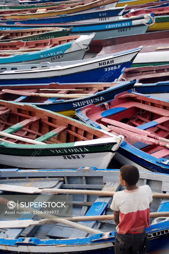 A boy thinking lonely watching the fishing boats in Ponta do sol harbour, Santo Antío island, Cape Verde archipelago, Africa