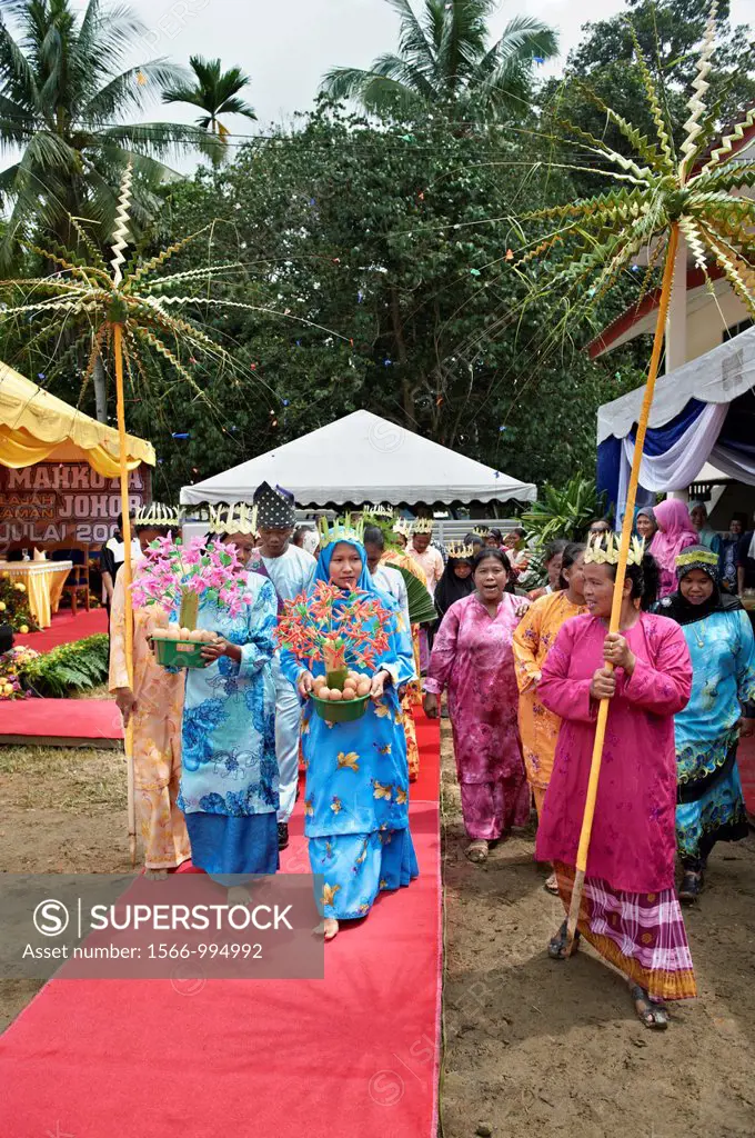 Malaysians in Johor dressed in traditional wear while carrying flowers