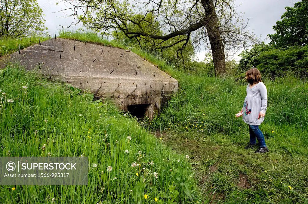 Utrecht, Netherlands. Old, Dutch military fortress from the Waterline near Utrecht, Netherlands. A WWII bunker is viewed by a schoolgirl.