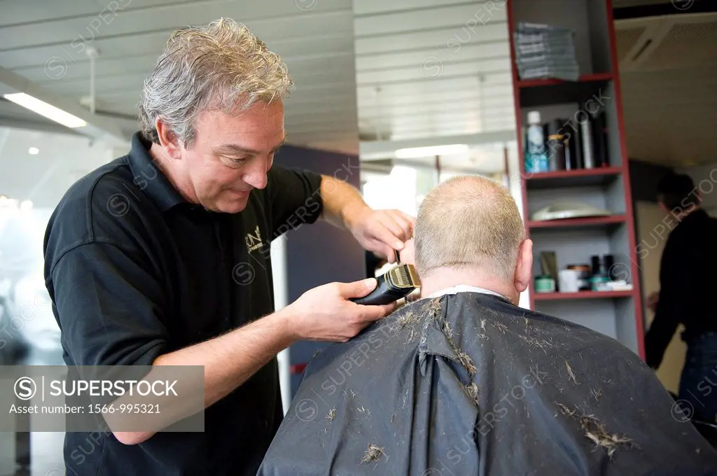 A barber giving a male customer a haircut.