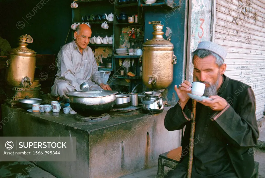 Blind man drinking tea in front of a tea shop. Pakistan. Tea has been gifted by the tea shop owner.