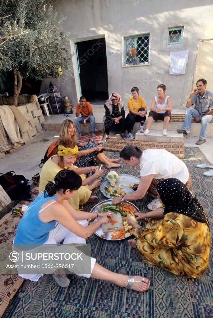 tourists taking part in the preparation of the dinner at villager´s house in the village of Um-Sayhoun where are living the most part of Bedoins worki...