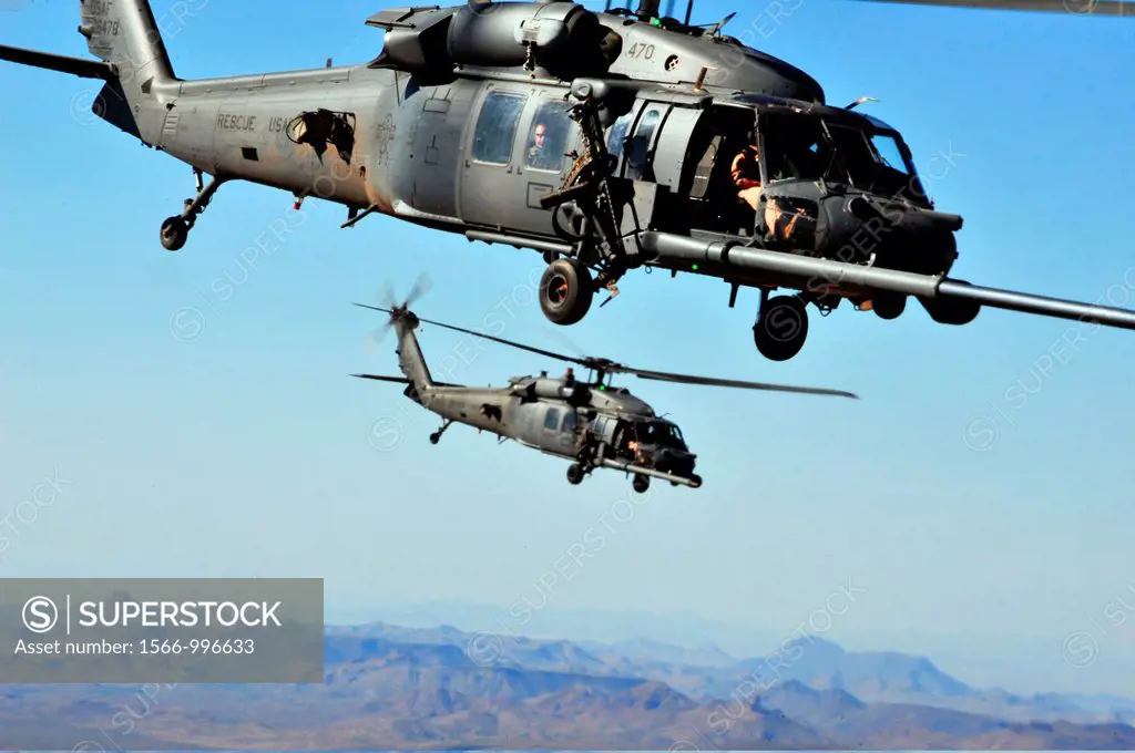 Two U S  Air Force HH-60 Pave Hawk helicopters from the 66th Rescue Squadron maneuver behind an HC-130 King aircraft to perform a helicopter air refue...