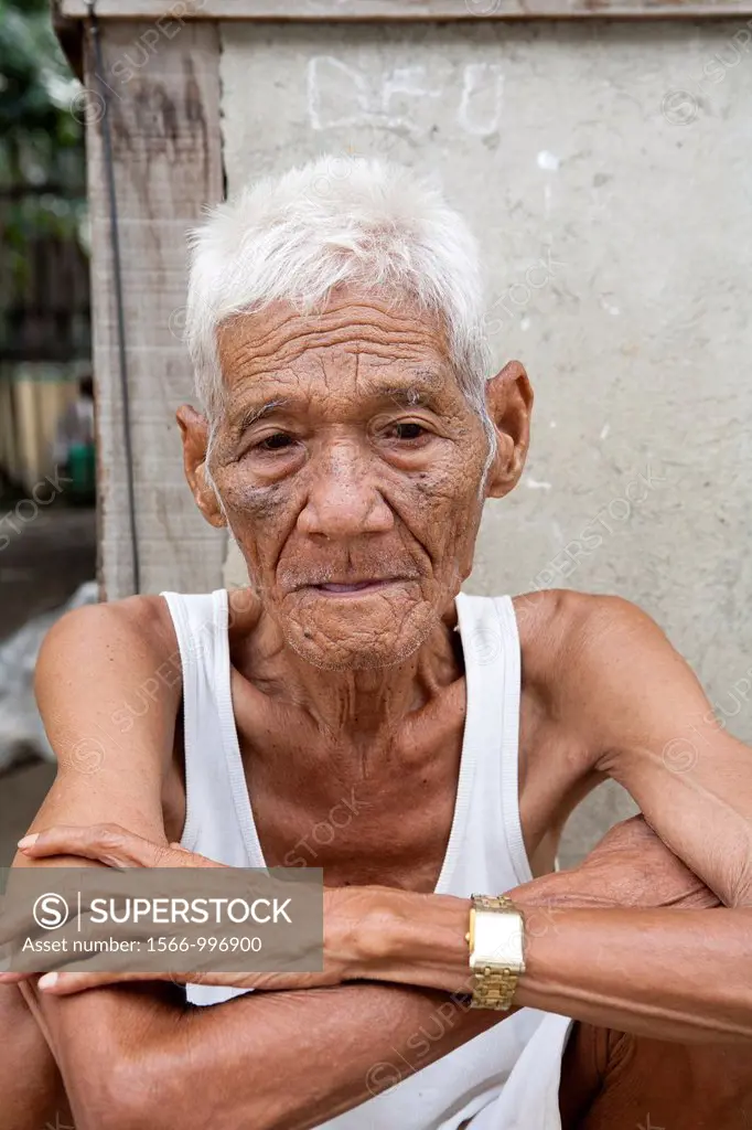 An old Filipino man sitting outside his home  Lapu-Lapu City, Metro Cebu, Mactan Island, Visayas, Philippines