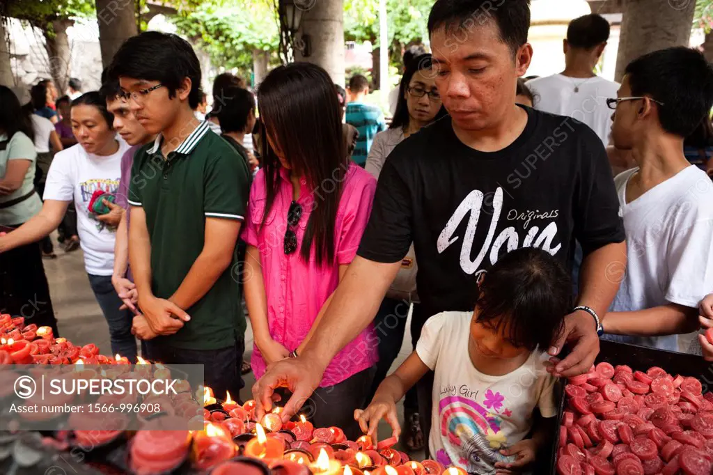 Filipinos lighting prayer candles during and after an outdoor sunday mass at The Minor Basilica of the Santo Nino, aka Basilica Minore del Santo Nino,...